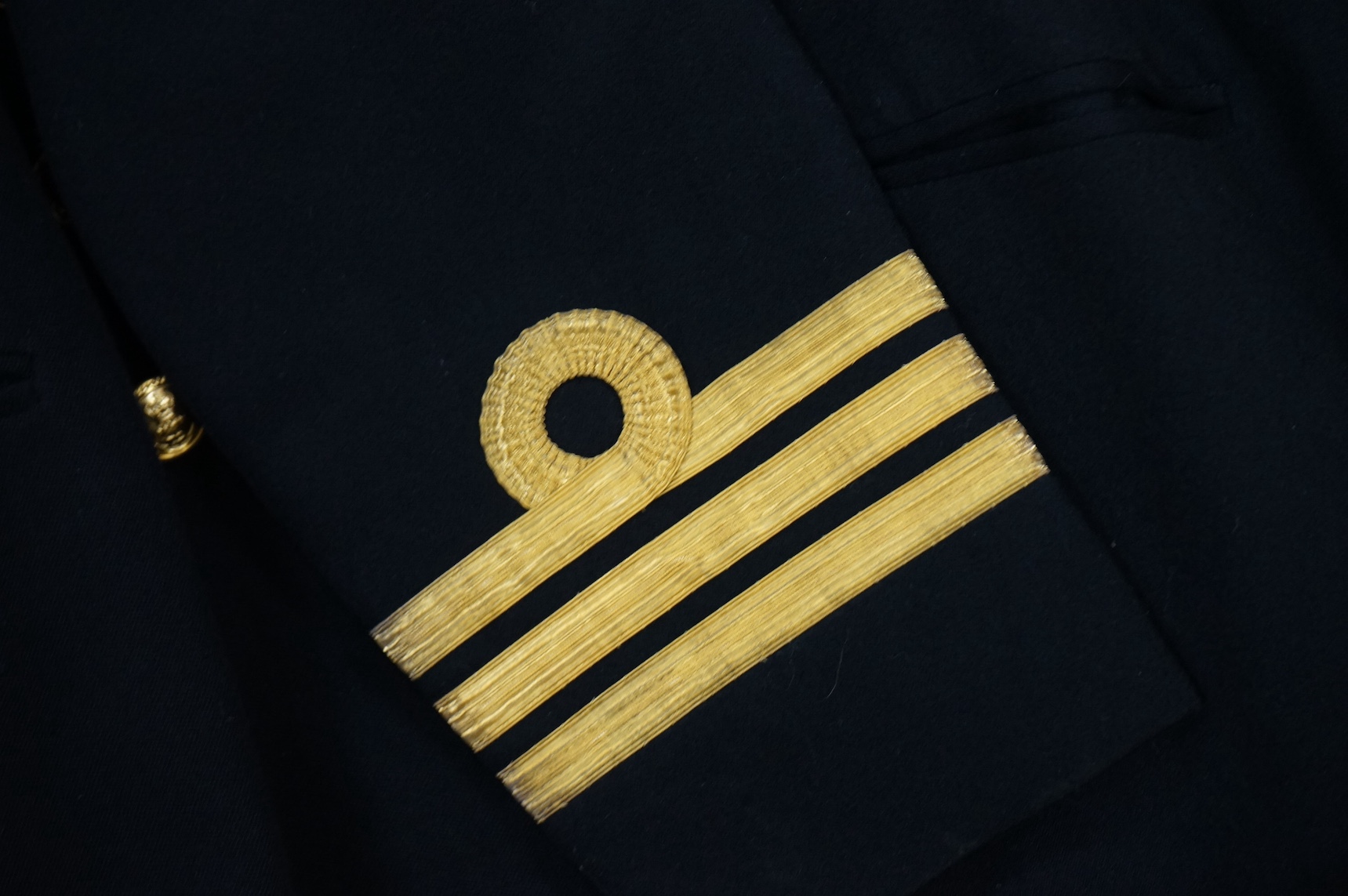 A Royal Navy officer's great coat, cap and four other Navy Officer's jackets. Condition - fair/good